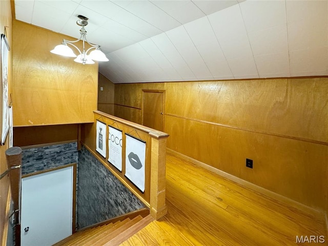 1001 Pike St, Saint Charles, MO 63301 - stairway with wood finished floors, vaulted ceiling, a chandelier, and wooden walls
