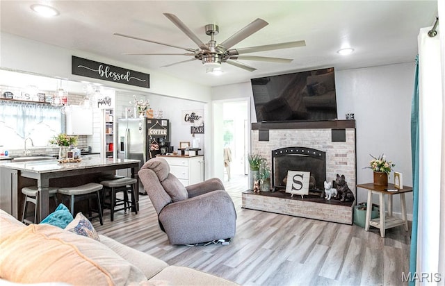 12310 State Route Hh, Rolla, MO 65401 - living room featuring light wood finished floors, ceiling fan, a fireplace, and recessed lighting