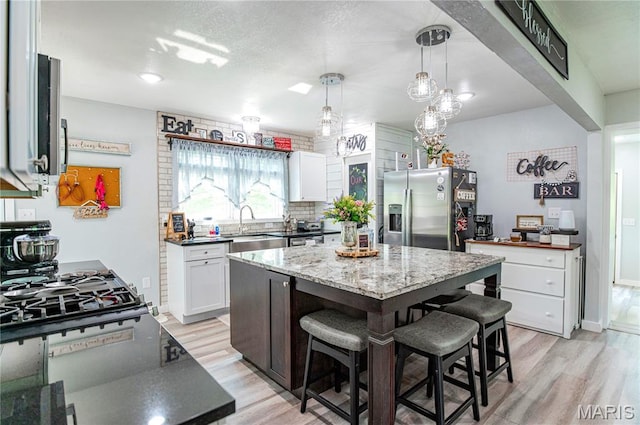 12310 State Route Hh, Rolla, MO 65401 - kitchen with stainless steel fridge with ice dispenser, a sink, light wood-style floors, and a kitchen breakfast bar