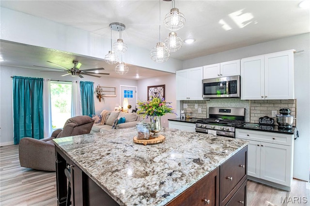 12310 State Route Hh, Rolla, MO 65401 - kitchen with stainless steel appliances, open floor plan, light wood finished floors, white cabinetry, and backsplash