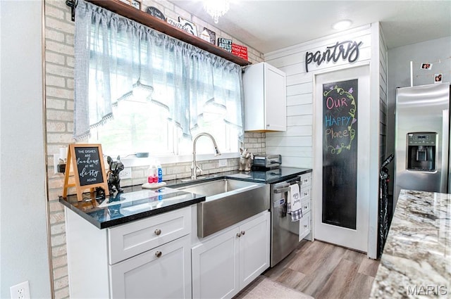12310 State Route Hh, Rolla, MO 65401 - kitchen featuring appliances with stainless steel finishes, a sink, light wood-style flooring, white cabinetry, and dark stone countertops