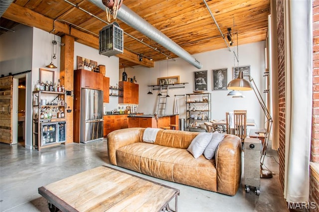 721 17th St Unit 207, Saint Louis, MO 63102 - living area featuring finished concrete flooring, a bar, wood ceiling, and a barn door