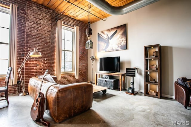 721 17th St Unit 207, Saint Louis, MO 63102 - living area featuring brick wall, a wood ceiling with exposed beams, and finished concrete flooring