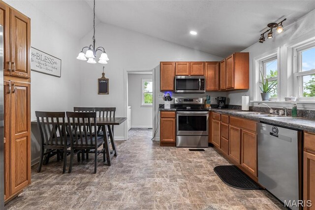 302 Bogy St, De Soto, MO 63020 - kitchen with stainless steel appliances, brown cabinets, healthy amount of natural light, dark countertops, and lofted ceiling