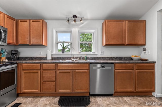 302 Bogy St, De Soto, MO 63020 - kitchen with appliances with stainless steel finishes, dark countertops, brown cabinets, and stone finish flooring