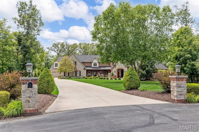701 Crown Pointe Farms, Defiance, MO 63341 - view of front facade featuring driveway, stone siding, and a front lawn