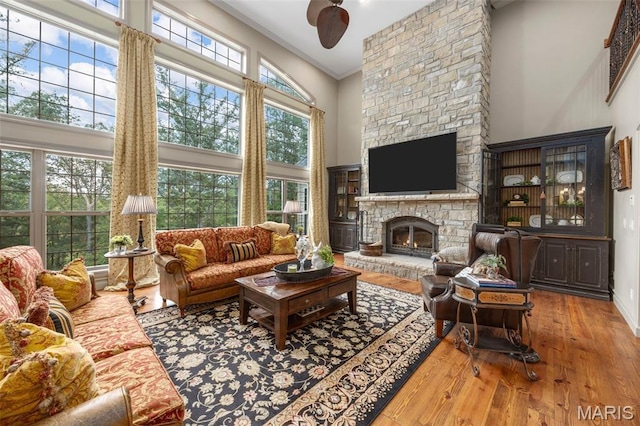 701 Crown Pointe Farms, Defiance, MO 63341 - living room with a stone fireplace, a towering ceiling, a ceiling fan, plenty of natural light, and wood finished floors