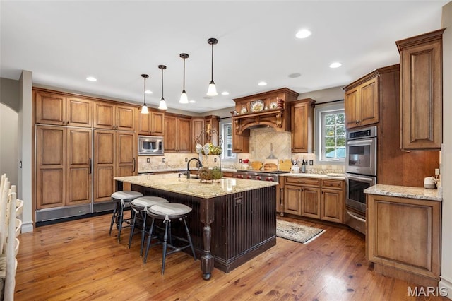 701 Crown Pointe Farms, Defiance, MO 63341 - kitchen featuring appliances with stainless steel finishes, a breakfast bar area, backsplash, brown cabinets, and light stone countertops