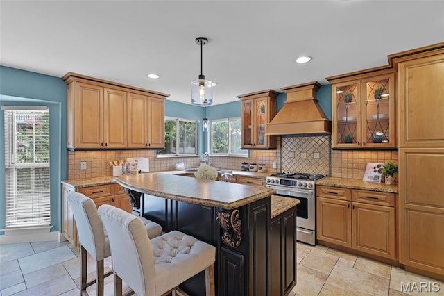 3038 Woodbridge Creek Dr, Saint Louis, MO 63129 - kitchen with stainless steel range with gas cooktop, premium range hood, a center island, a breakfast bar, and recessed lighting