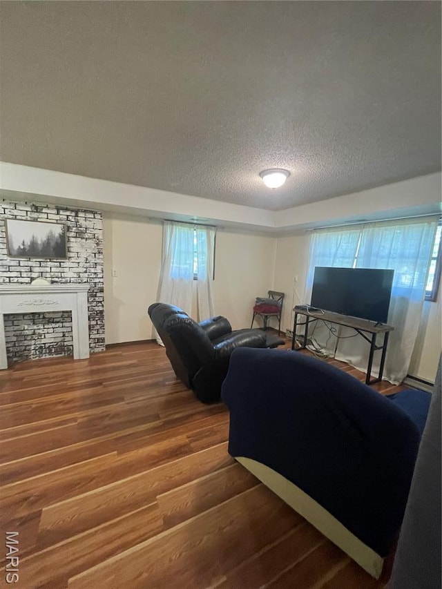 128 Myers St, Licking, MO 65542 - living room with a textured ceiling, wood finished floors, a fireplace, and plenty of natural light