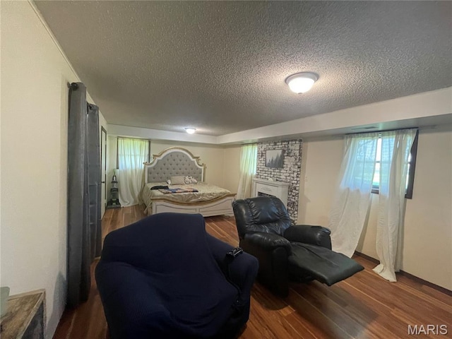 128 Myers St, Licking, MO 65542 - sitting room with a textured ceiling, wood finished floors, and a brick fireplace