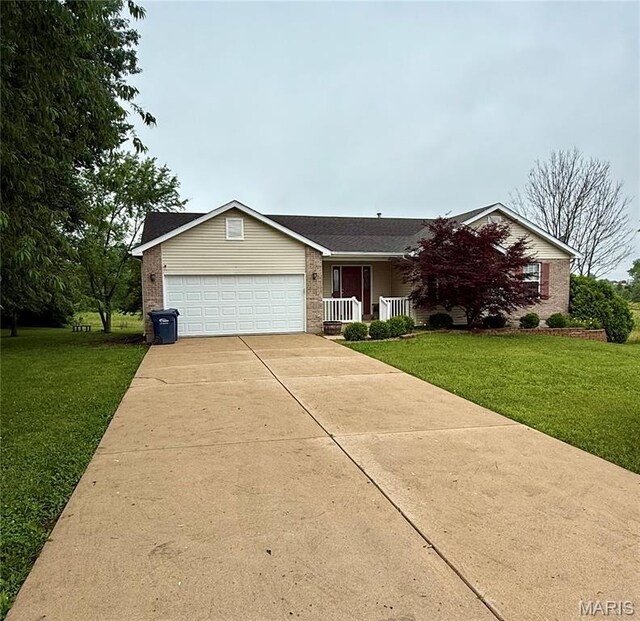 51 Tower St, Moscow Mills, MO 63362 - view of front of home featuring a front lawn, a garage, concrete driveway, and brick siding