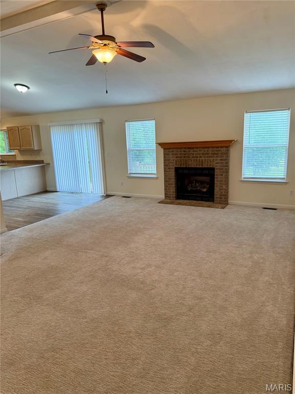 51 Tower St, Moscow Mills, MO 63362 - unfurnished living room featuring ceiling fan, light carpet, and a fireplace
