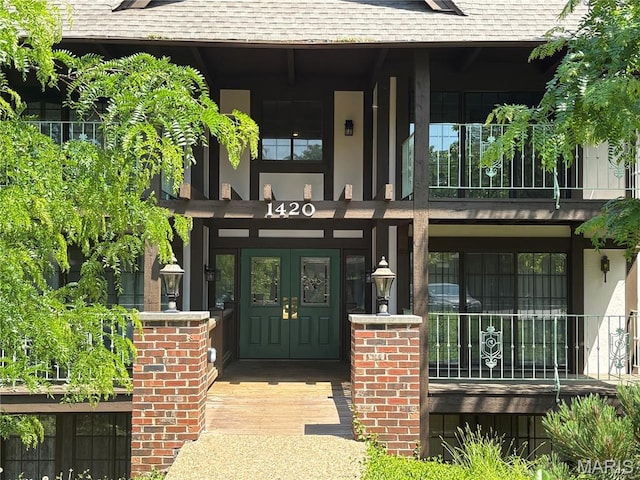 1420 Heritage Lndg Unit 107, Saint Charles, MO 63303 - entrance to property featuring roof with shingles, covered porch, stucco siding, french doors, and a balcony