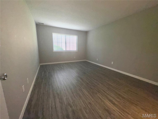 1420 Heritage Lndg Unit 107, Saint Charles, MO 63303 - spare room featuring dark wood finished floors and baseboards