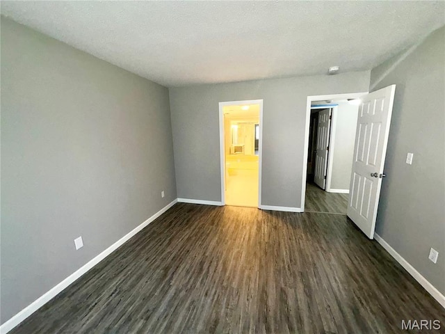 1420 Heritage Lndg Unit 107, Saint Charles, MO 63303 - unfurnished bedroom with dark wood finished floors and connected bathroom