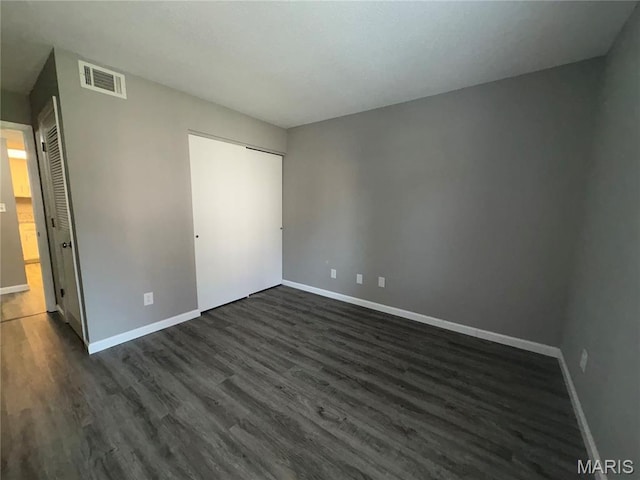 1420 Heritage Lndg Unit 107, Saint Charles, MO 63303 - unfurnished bedroom featuring baseboards and dark wood-style flooring