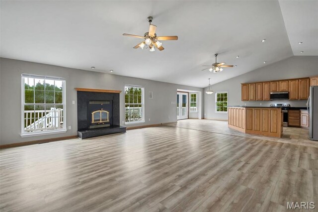2518 Nike Base Rd, Catawissa, MO 63015 - unfurnished living room with ceiling fan, plenty of natural light, light wood-style flooring, vaulted ceiling, and a glass covered fireplace