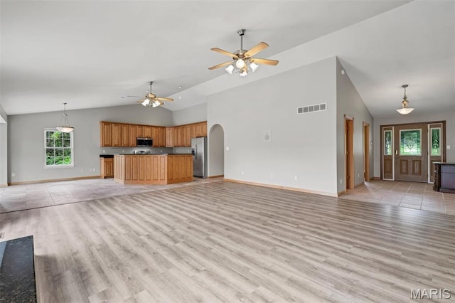 2518 Nike Base Rd, Catawissa, MO 63015 - unfurnished living room featuring light wood-style floors, a ceiling fan, arched walkways, and high vaulted ceiling