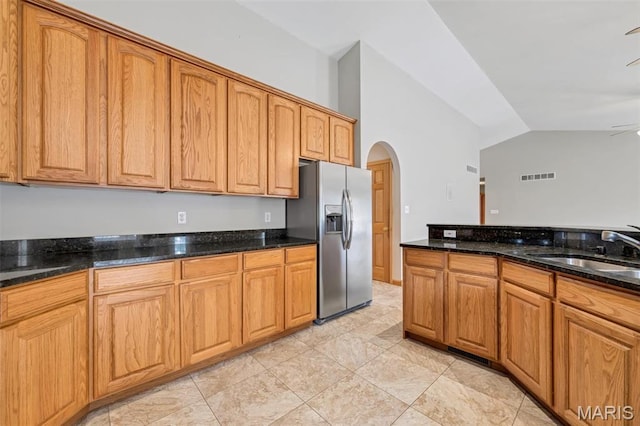 2518 Nike Base Rd, Catawissa, MO 63015 - kitchen with stainless steel refrigerator with ice dispenser, arched walkways, lofted ceiling, dark stone counters, and ceiling fan