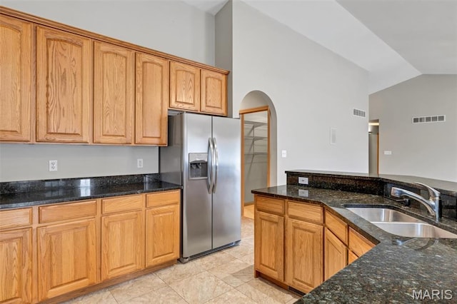 2518 Nike Base Rd, Catawissa, MO 63015 - kitchen featuring stainless steel fridge, arched walkways, lofted ceiling, dark stone countertops, and light tile patterned flooring