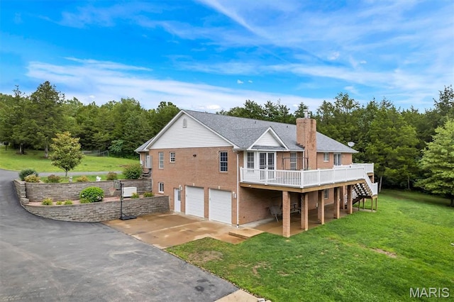 2518 Nike Base Rd, Catawissa, MO 63015 - back of property with a garage, brick siding, a deck, a chimney, and concrete driveway
