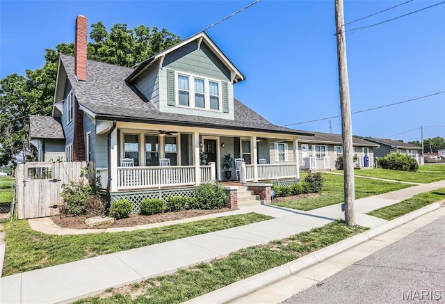 201 S Columbus St, Pacific, MO 63069 - bungalow-style house with covered porch, a chimney, a gate, a front yard, and roof with shingles