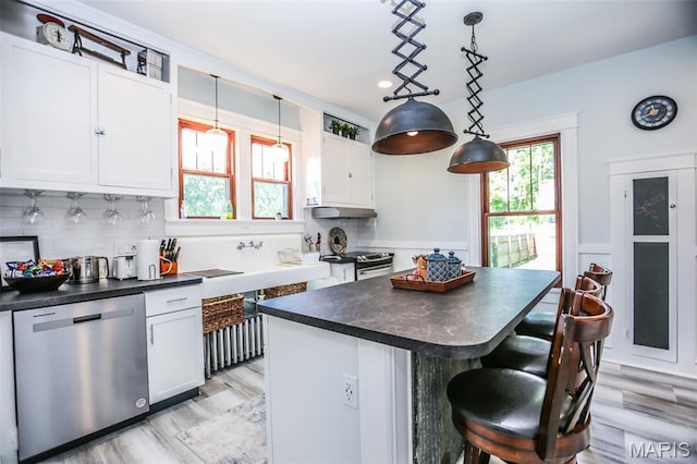 201 S Columbus St, Pacific, MO 63069 - kitchen featuring appliances with stainless steel finishes, dark countertops, a kitchen island, white cabinetry, and recessed lighting