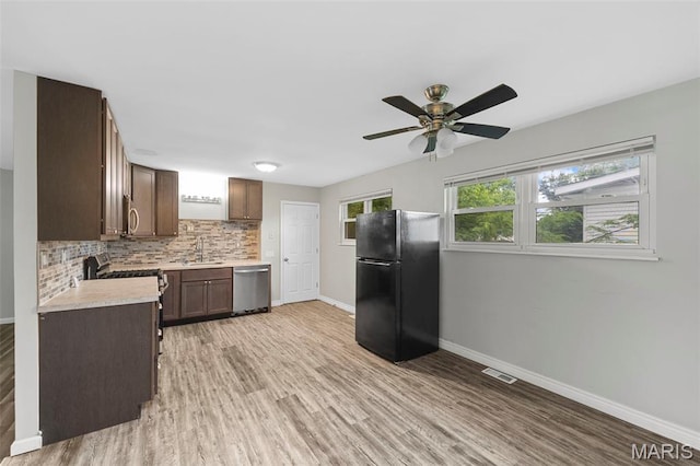 2185 Orleans Ln, Florissant, MO 63031 - kitchen featuring stainless steel appliances, light countertops, light wood-type flooring, and tasteful backsplash
