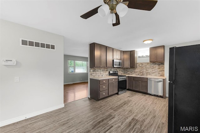 2185 Orleans Ln, Florissant, MO 63031 - kitchen featuring stainless steel appliances, light wood-style flooring, light countertops, and ceiling fan