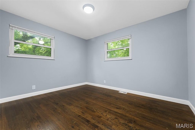 2185 Orleans Ln, Florissant, MO 63031 - spare room featuring baseboards and dark wood-type flooring