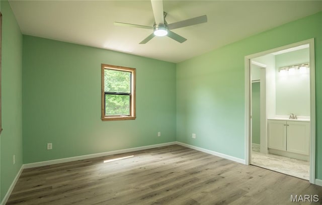 201 W 5th St, Grandin, MO 63943 - unfurnished bedroom featuring wood finished floors, ensuite bathroom, and ceiling fan