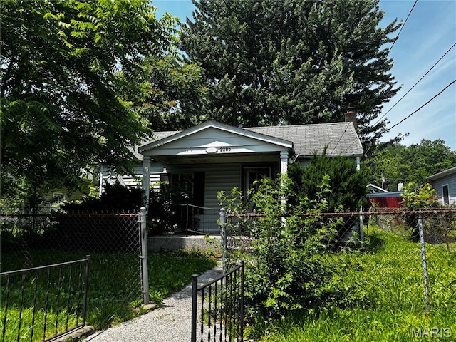 2205 N 5th St, Saint Charles, MO 63301 - bungalow with a porch, a fenced front yard, and a chimney