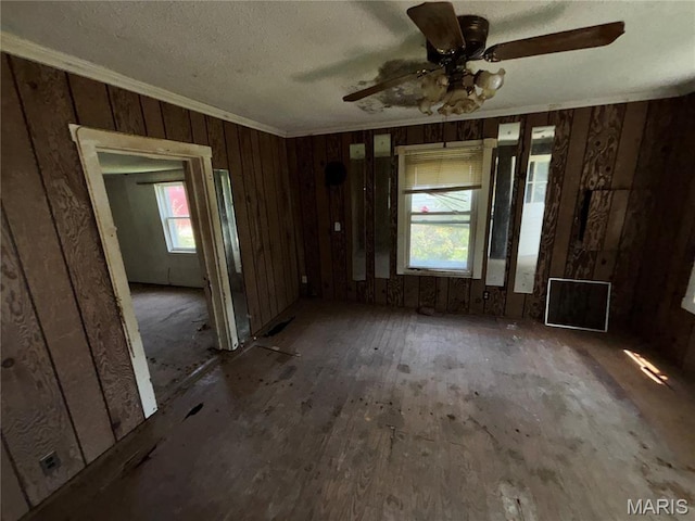 2205 N 5th St, Saint Charles, MO 63301 - unfurnished living room with crown molding, wood walls, and a ceiling fan