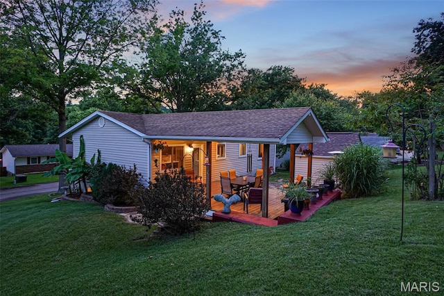1809 Partridge Dr, Windsor Township, MO 63052 - back of house at dusk featuring a lawn and roof with shingles
