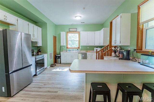 10201 County Road 5440, Rolla, MO 65401 - kitchen featuring appliances with stainless steel finishes, a peninsula, plenty of natural light, and light wood-type flooring