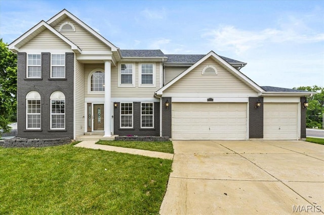 4507 Behlmann Grove Pl, Florissant, MO 63034 - view of front facade featuring driveway, a garage, a front yard, and brick siding