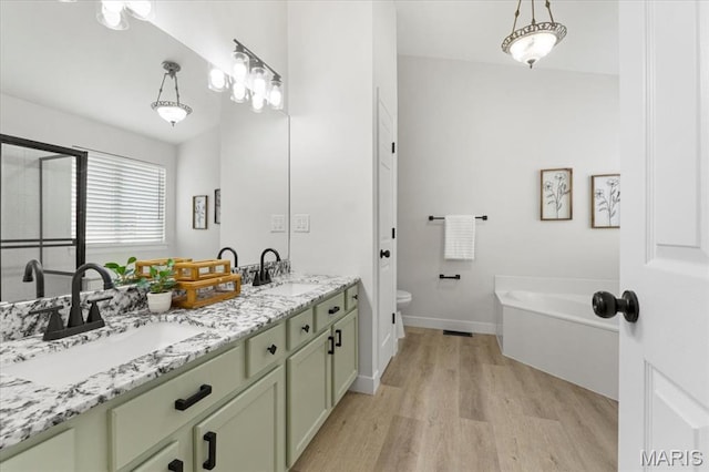 4507 Behlmann Grove Pl, Florissant, MO 63034 - bathroom featuring wood finished floors, double vanity, and a garden tub