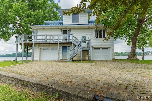 380 Yachtview Dr, West Alton, MO 63386 - coastal inspired home with an attached garage, a metal roof, stairway, and a deck with water view