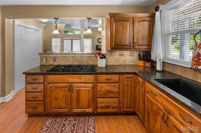 900 Danforth St, Alton, IL 62002 - kitchen with black gas stovetop, light wood-type flooring, brown cabinets, and tasteful backsplash
