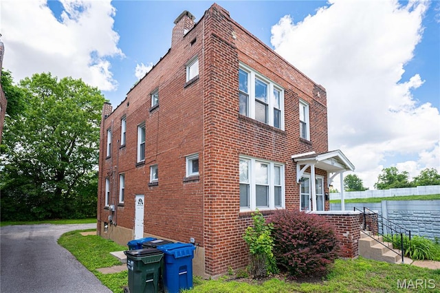 1323 Woodland Dr, Saint Louis, MO 63117 - view of property exterior featuring brick siding and a chimney