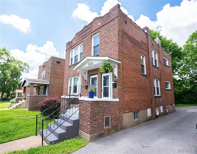 1323 Woodland Dr, Saint Louis, MO 63117 - view of front of house with brick siding and a front yard
