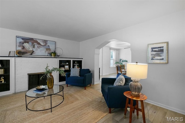 4950 Eichelberger St, Saint Louis, MO 63109 - living room with arched walkways, wood finished floors, and a brick fireplace