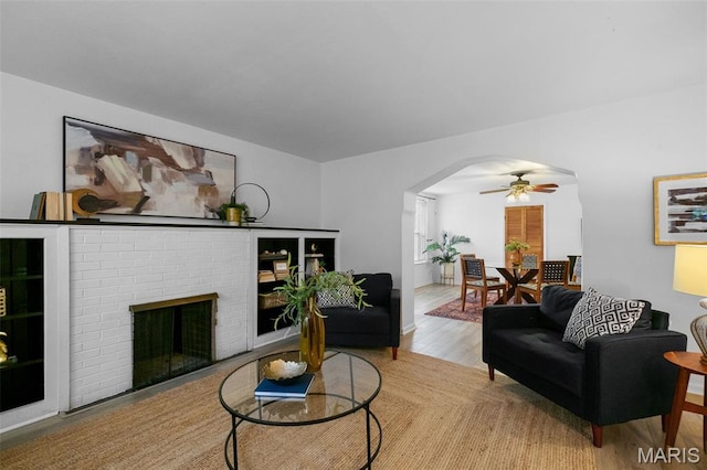 4950 Eichelberger St, Saint Louis, MO 63109 - living area with ceiling fan, arched walkways, a brick fireplace, and wood finished floors