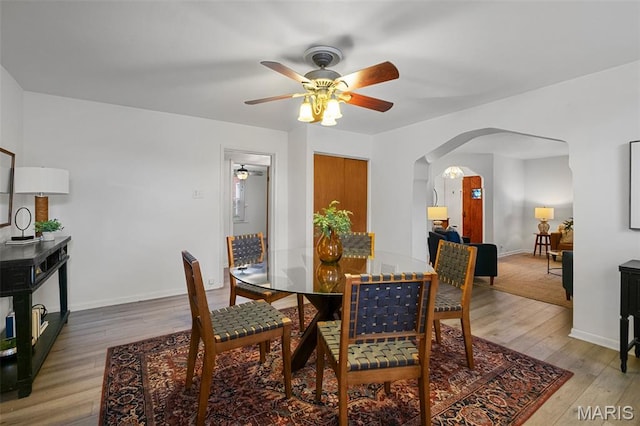 4950 Eichelberger St, Saint Louis, MO 63109 - dining room with arched walkways, ceiling fan, and light wood-style flooring