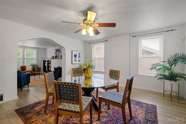 4950 Eichelberger St, Saint Louis, MO 63109 - dining room with arched walkways, light wood-style floors, and a ceiling fan