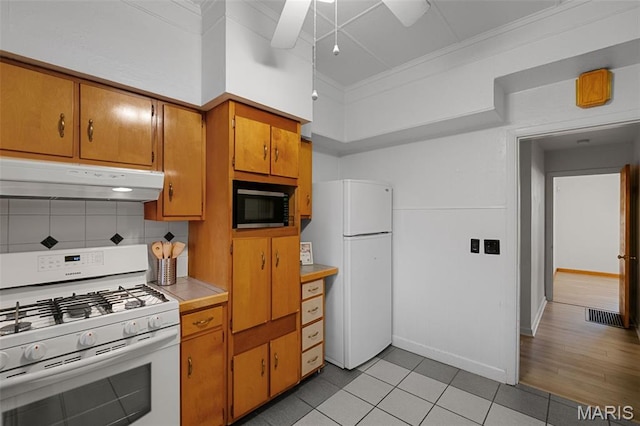 4950 Eichelberger St, Saint Louis, MO 63109 - kitchen featuring white appliances, under cabinet range hood, light countertops, brown cabinets, and tasteful backsplash