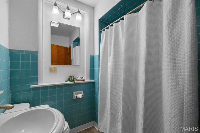 4950 Eichelberger St, Saint Louis, MO 63109 - bathroom featuring tile walls, curtained shower, and a wainscoted wall