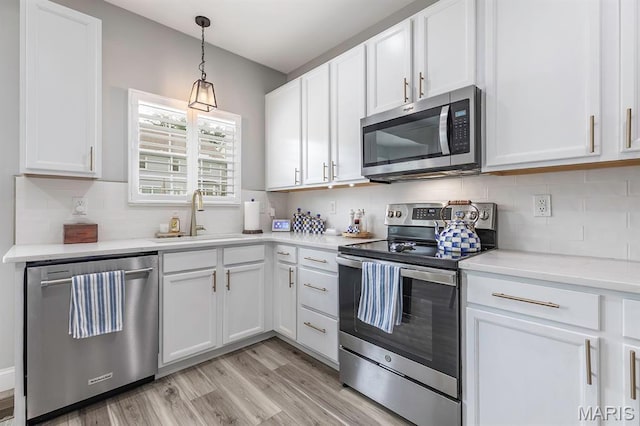2625 Grover Crossing Way, Wildwood, MO 63040 - kitchen with appliances with stainless steel finishes, white cabinets, decorative backsplash, and light wood-style floors