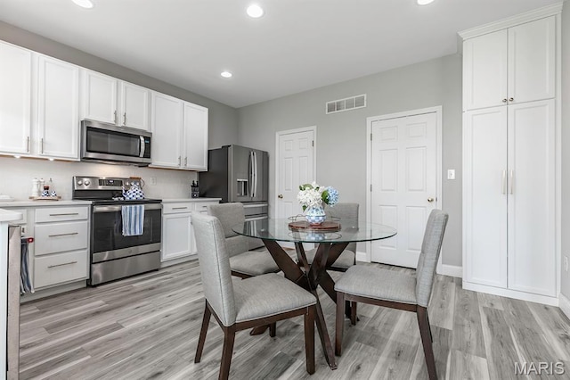 2625 Grover Crossing Way, Wildwood, MO 63040 - kitchen with appliances with stainless steel finishes, light wood-type flooring, recessed lighting, white cabinetry, and light countertops